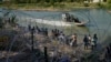 Inmigrantes que cruzaron a Estados Unidos desde México se encuentran con alambre de púas a lo largo del Río Grande, en Eagle Pass, Texas. (AP/Eric Gay, File)