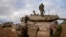 Soldados israelíes trabajan en un tanque en un puesto del ejército cerca de la frontera con Gaza, en el sur de Israel, el 27 de noviembre de 2023. (AP Foto/Ohad Zwigenberg)