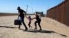 Una familia de migrantes cubanos se apresura a cruzar la frontera en Yuma, Arizona, en mayo de 2021. (Ringo Chiu/ AFP)