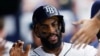 Yandy Díaz, de los Rays de Tampa Bay, es felicitado en el banquillo luego de anotar contra los Guardianes de Cleveland, este, sábado 12 de agosto, en St. Petersburg, Florida (AP/Scott Audette)