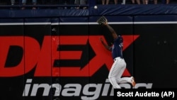 Randy Arozarena atrapa un fly bateado por Rafael Denvers, de los Medias Rojas de Boston, en el juego de este martes, 11 de abril, en St. Petersburg, Florida. (AP/Scott Audette)