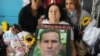 Amelia García, madre de José Daniel Ferrer, sostiene un afiche con la imagen de su hijo durante una manifestación en Miami por su liberación. 