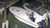 Las autoridades revisan el bote en el que arribaron los migrantes. (Captura de video/CBS Miami)