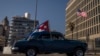 Foto Archivo. Un carro con la bandera cubana pasa frente a la Embajada de Estados Unidos en Cuba. 
