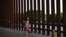 Niña centroaméricana camina junto a la valla México-EEUU